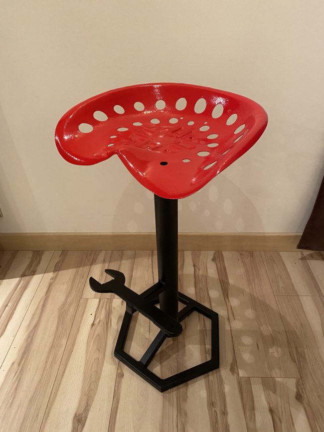 Tabouret de bar industriel avec ancien siège de tracteur rouge