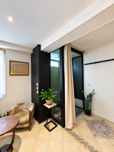 Rénovation d’un salon à Saint-Amand-Montrond avec murs clairs, plafond blanc et papier peint conservé