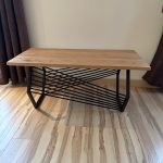 Table basse bois et métal sur mesure avec plateau en bois naturel et piètement géométrique en acier noir.