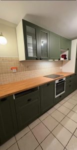 Agencement cuisine à Tours avec meubles vert olive, plan de travail bois et papier peint panoramique