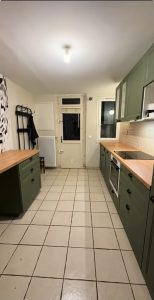 Agencement cuisine à Tours avec meubles vert olive, plan de travail bois et papier peint panoramique