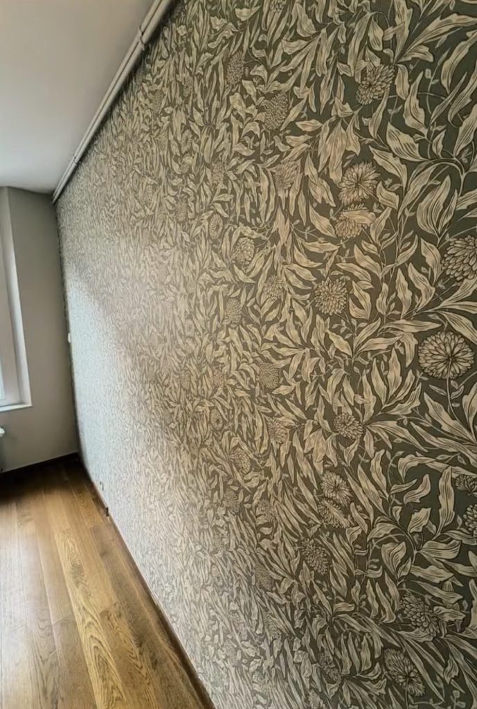 Rénovation d’une chambre à Tours avec murs et plafond repeints et pose d’un papier peint floral dans les tons vert et beige.