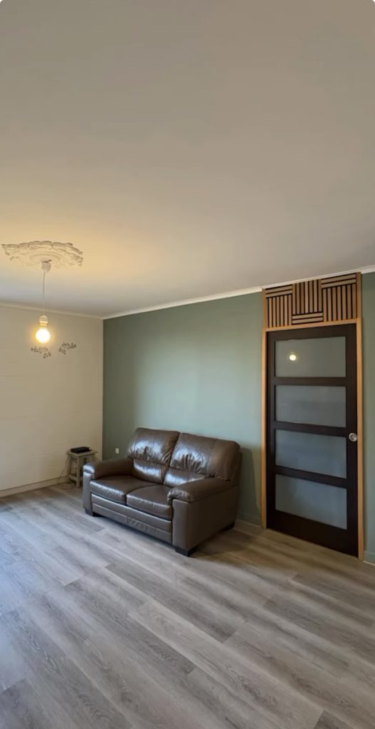 Rénovation d’un séjour avec pose de papier peint à motifs feuillages et peinture de deux couleurs assorties, avec conseil déco Bouchard Peinture.