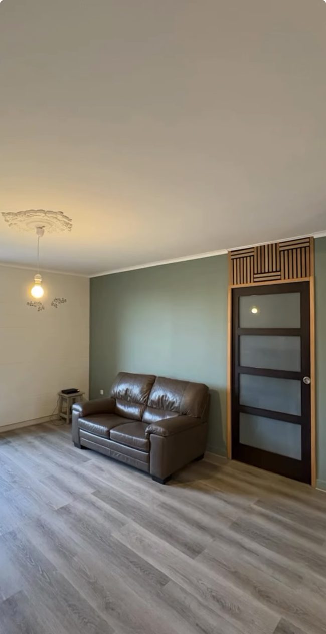 Rénovation d’un séjour avec pose de papier peint à motifs feuillages et peinture de deux couleurs assorties, avec conseil déco Bouchard Peinture.